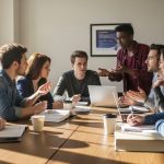 Diverse group of college students sitting around table discussing and resolving study team conflict collaboratively