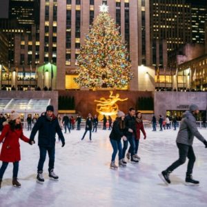 Ice skaters gliding on the rink beneath the Rockefeller Center tree